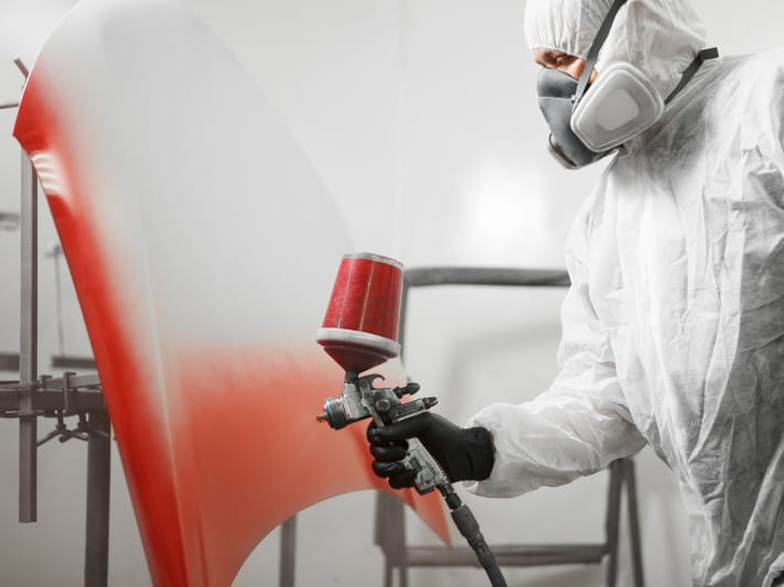 Spraying Red Paint On Car Hood